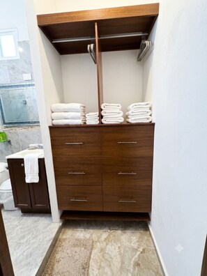 Une salle de bain avec un meuble-lavabo en bois, un miroir et un porte-serviettes.