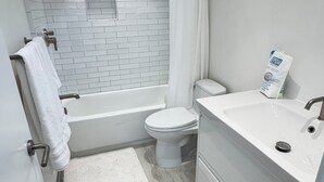 Ein modernes Badezimmer mit Badewanne, Toilette und Waschbecken.