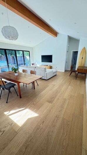 Un salon spacieux avec une table à manger en bois, un canapé et un téléviseur.
