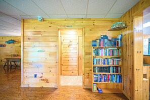 A wooden interior with a bookshelf, a door labeled 'Washroom,' and a small table. - Spacious Lodge @Madawaska |Ideal for Groups|Trails (Lake Saint Peter)