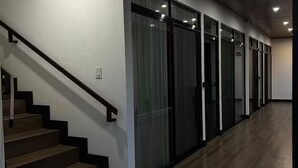 A hallway with a wooden staircase and glass doors. - Duke's Place 3 (Quepos)