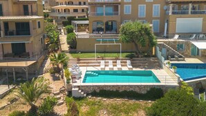 Área residencial com piscina, várias varandas e céu claro.