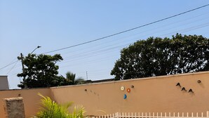 A fenced outdoor area with a pool, a potted plant, and a tiled floor.