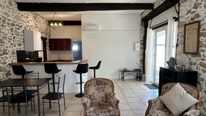 A spacious living area with a kitchen, dining set, and two patterned armchairs. - ROMY - DAX - City Break (DAX)