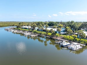 A marina with boats docked, surrounded by greenery and buildings. - Pet Friendly NSB Condo with Boat Slip up to 30 Ft near Flagler Avenue (New Smyrna Beach)