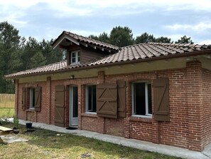 A brick building with a tiled roof, multiple windows with shutters, and a door. - COUDERE House - SOUSTONS (SOUSTONS)