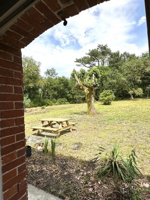 A brick building with a wooden picnic table in a grassy outdoor area. - COUDERE House - SOUSTONS (SOUSTONS)