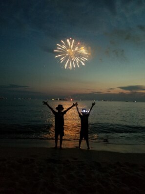 Two silhouetted figures on a beach, facing a fireworks display over the water. - Pet Friendly cottage w/ game room by Delaware Bay Beach (Lower Township)