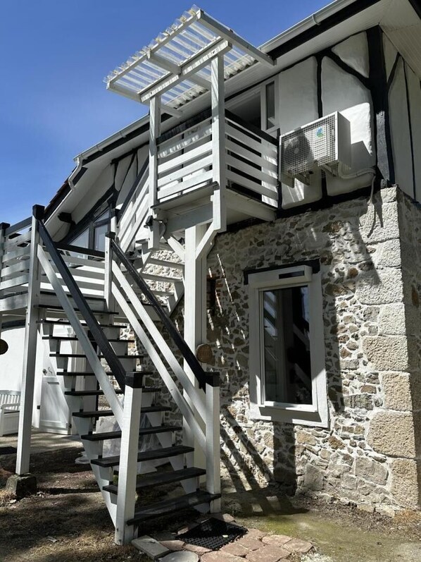 Ein Steinhaus mit einer Treppe, die zu einem Balkon führt.