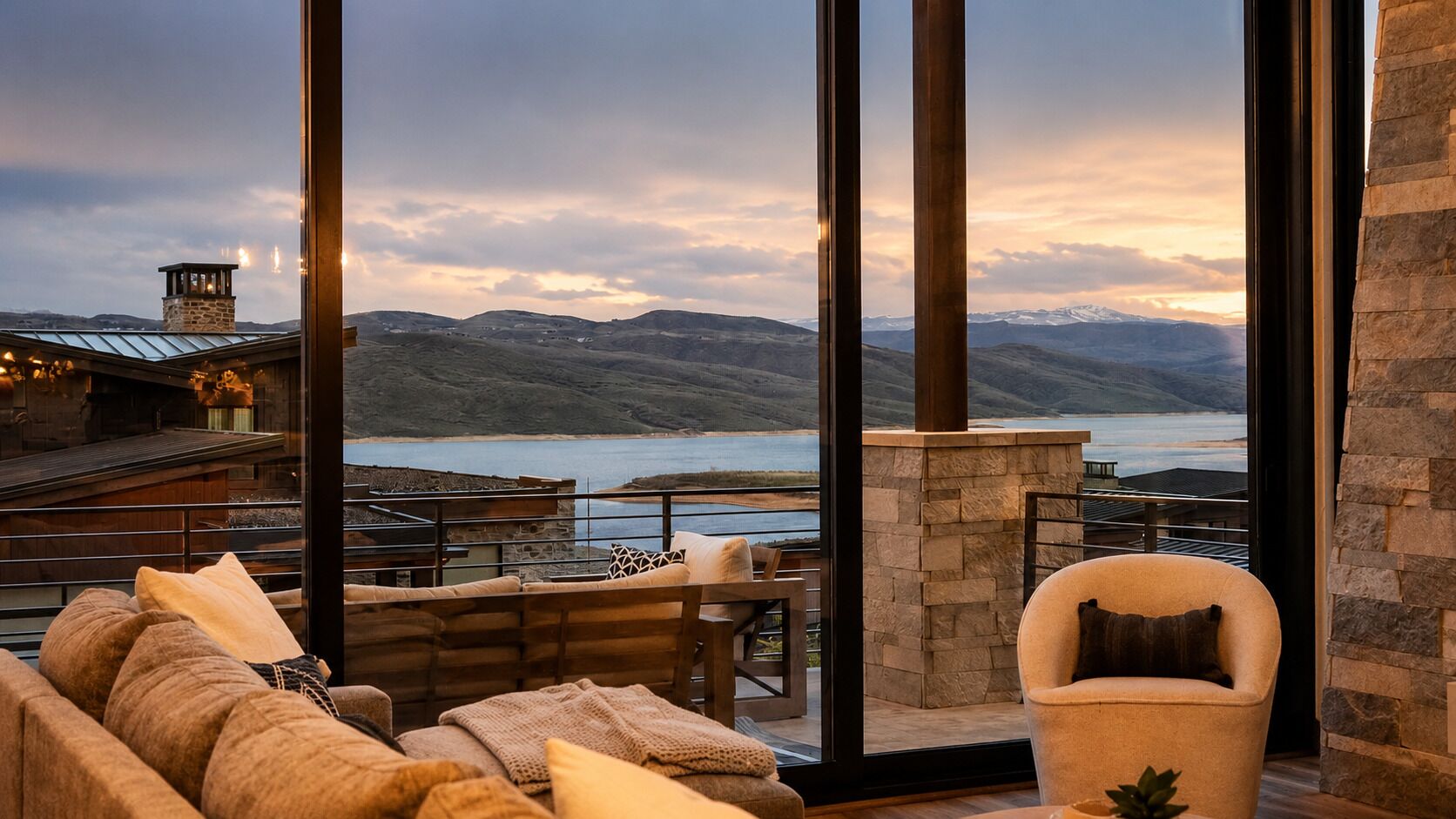 A modern interior with a large window overlooking a scenic lake and mountains.