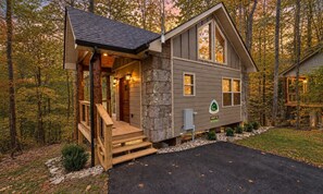 A cabin with a stone exterior, a wooden deck, and a front porch. - Trailhead Lodge #12 | Gatlinburg 24 min (Cosby)