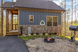 A lodge with a stone foundation, a fire pit, and a mailbox. - Trailhead Lodge #13 Loft + Fire Pit (Cosby)