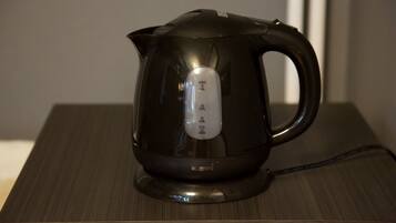 A black electric kettle on a wooden table.