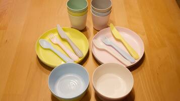 A wooden table with four sets of cutlery and bowls.