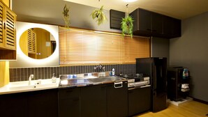 A modern kitchen with a large island, built-in appliances, and a circular mirror.