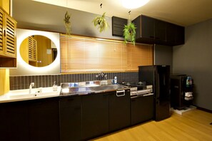 A modern kitchen with a large island, built-in appliances, and a circular mirror.
