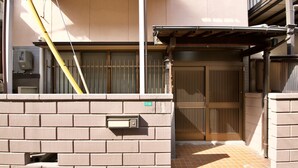 A building with a brick wall, a mailbox, and a gated entrance.