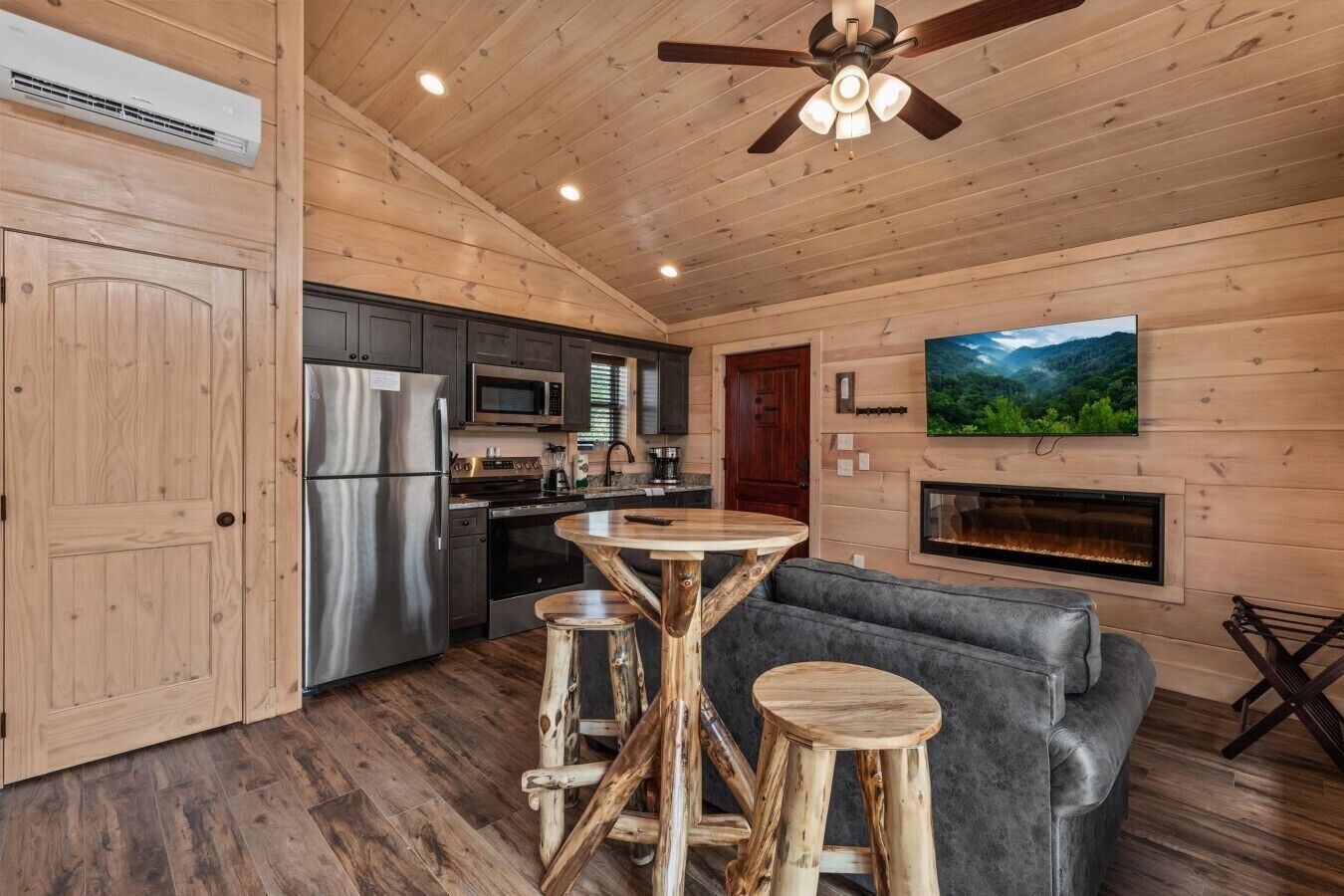 Un interior de madera con cocina, comedor y chimenea.
