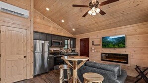 Un intérieur en bois comprenant une cuisine, un coin repas et une cheminée.