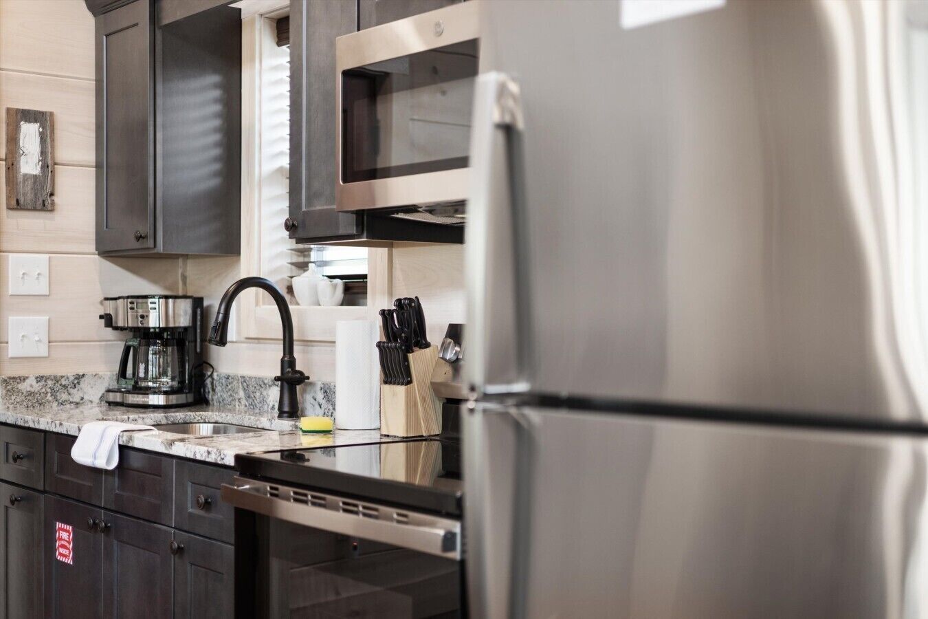 Una cocina moderna con electrodomésticos de acero inoxidable, una cafetera y un juego de cuchillos.