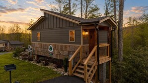 A two-story cabin with a wooden deck and a staircase leading to the upper level. - Gatlinburg 24 min | HotTub +King Bed #8 (Cosby)