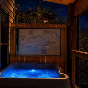 En træhytte med jacuzzi og et kort på væggen.