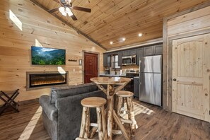 Un interior de madera con chimenea, cocina y zona de estar.