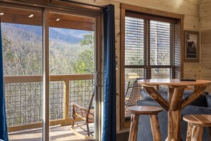 Un interior de madera con balcón, una mesa y una silla.