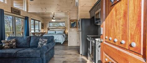 L’intérieur d’une cabine comprenant un canapé, un lit, un coin cuisine et un espace repas.