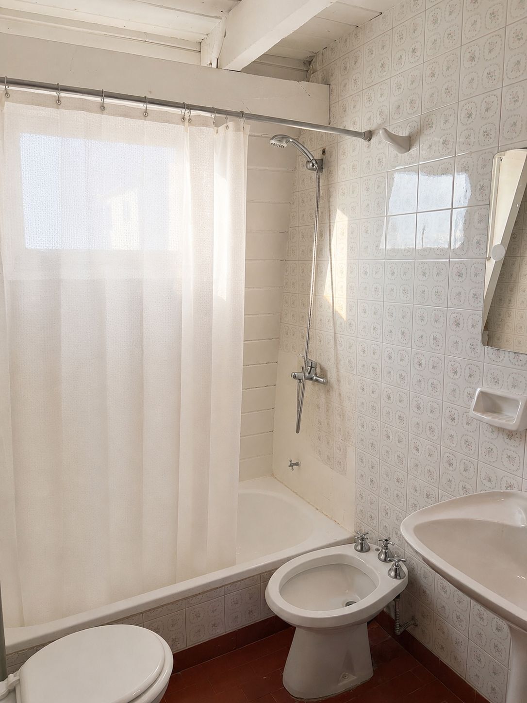 A bathroom with a shower, toilet, and sink.