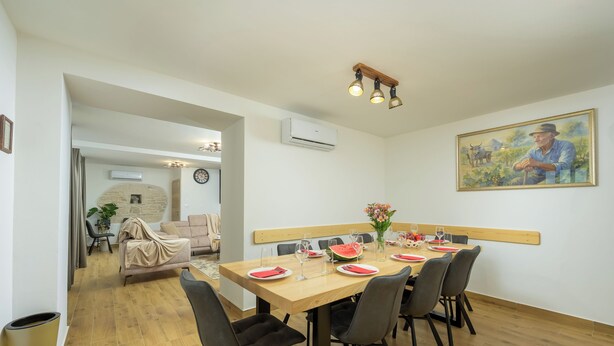 A dining area with a wooden table, black chairs, and a painting on the wall. - Villa Tone i Maria (Istria - Matohanci) (Matohanci)