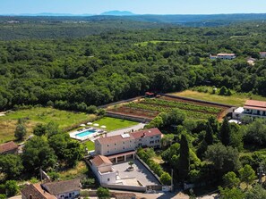 An aerial view of a property with a swimming pool, a large building with a tiled roof, and surrounding greenery. - Villa Tone i Maria (Istria - Matohanci) (Matohanci)