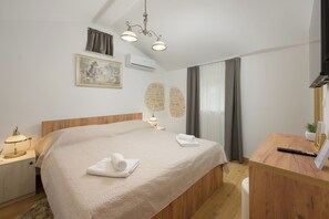 A bedroom with a bed, bedside table, lamp, air conditioning unit, and a painting on the wall. - Villa Tone i Maria (Istria - Matohanci) (Matohanci)