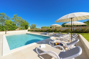 A swimming pool with lounge chairs and umbrellas, surrounded by greenery. - Villa Tone i Maria (Istria - Matohanci) (Matohanci)