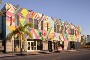 Un bâtiment moderne doté d’une façade géométrique aux couleurs vives, de grandes fenêtres et d’une devanture avec une enseigne bien visible.