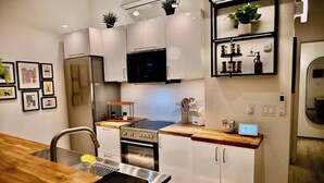 Une cuisine moderne dotée d’appareils électroménagers en acier inoxydable, de plans de travail en bois et d’un four encastré.