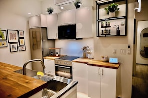 Een moderne keuken met roestvrijstalen apparatuur, houten aanrecht en een ingebouwde oven.
