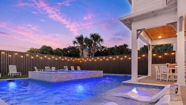 Un jardin avec une piscine, des chaises longues et un patio couvert.