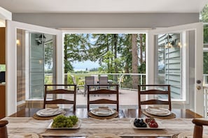 Comedor abierto con vista a árboles y una terraza.