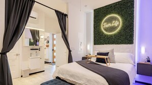 Un dormitorio moderno con cama, mesita de noche y un letrero de neón en la pared.