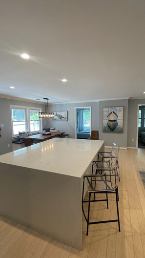 A spacious kitchen with a large island, bar stools, and a view of the outdoors. - Downtown Rehoboth Beach Easy Walk to Beach Porch (Rehoboth Beach)