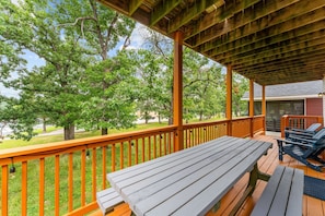 A covered outdoor deck with wooden benches and tables, surrounded by trees. - Steps to Table Rock Lake & Port of Kimberling_Free Attraction Tickets (Kimberling City)