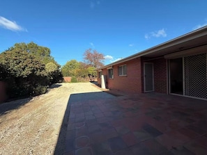 A residential property with a paved driveway, a garage with a sliding door, and a brick exterior. - Inner North Gem | King Room Near ANU and City Centre (Turner)