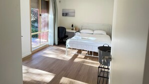 A bedroom with a bed, a desk, a chair, a window, and a door. - Sunny King Room | 5-Min Walk to ANU | Near City (Turner)