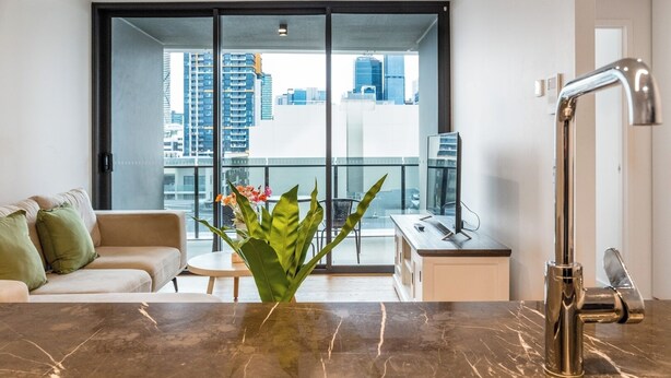 Een modern appartement met een keuken, een eethoek en een balkon met uitzicht op de stad.