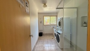 A laundry room with a washing machine, dryer, and a window with a view.