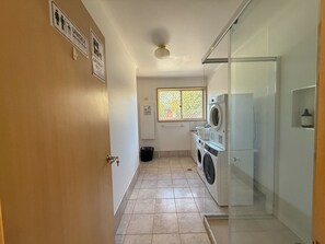 A laundry room with a washing machine, dryer, and a glass shower enclosure. - Centrally Located Private Oasis | Minutes to Civic (Turner)