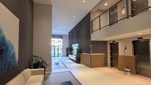 A modern lobby with a sofa, a round table, and a reception desk.