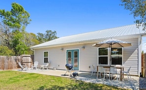 A single-story house with a patio, outdoor seating, and a barbecue grill. - Laguna Beach,Walk to Beach, Oleander by the Sea, Garage (Panama City Beach)