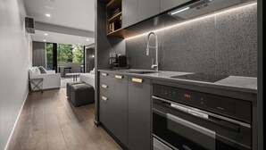 Een moderne keuken met een inbouwoven, een magnetron en een spoelbak.